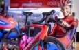Cycliste de l'équipe Roland souriant à côté d'un vélo Pinarello rouge