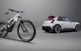Un VTT électrique Lapierre GLP III SE blanc à côté d'une voiture Alpine blanche sur fond gris.