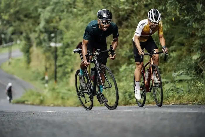 Deux cyclistes grimpant une côte en sprintant