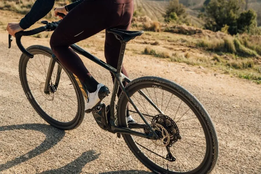 Gros plan sur un cycliste en danseuse sur un vélo de gravel