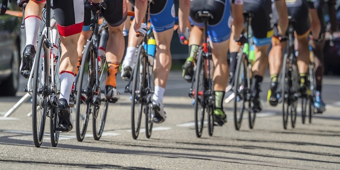 Gros plan sur les jambes des coureurs dans un peloton de cyclistes