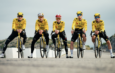 Cinq coureurs de l'équipe cycliste Visma Lease a Bike posant avec leurs vélos sur une route.