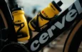 Deux bidons jaunes CamelBak Team Visma fixés sur le cadre noir d'un vélo Cervélo.