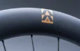 Jante noire d'une roue Reserve SL avec logo doré et fixation des rayons.