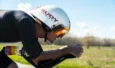 Cycliste en position de contre-la-montre équipé d'un casque blanc Rudy Project à visière.