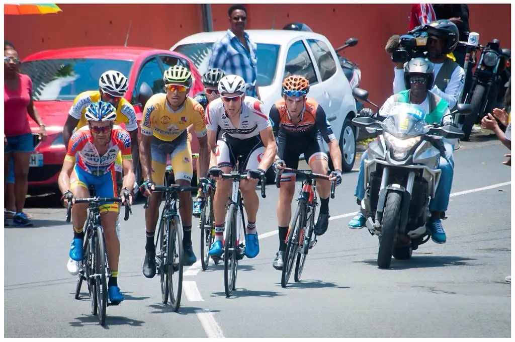 Boris Carène dans un groupe du Tour de Guadeloupe accompagné par une moto de télévision.