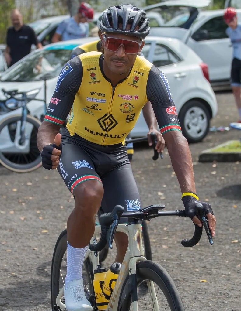 Boris Carène sur son vélo, adressant un pouce levé à l’objectif lors des dernières années de sa carrière en Guadeloupe.