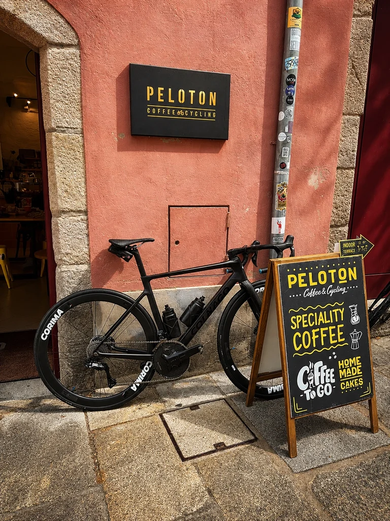 Façade du Peloton Café & Cycling, rue do Poço à Viana do Castelo, avec un vélo stationné devant l’entrée.