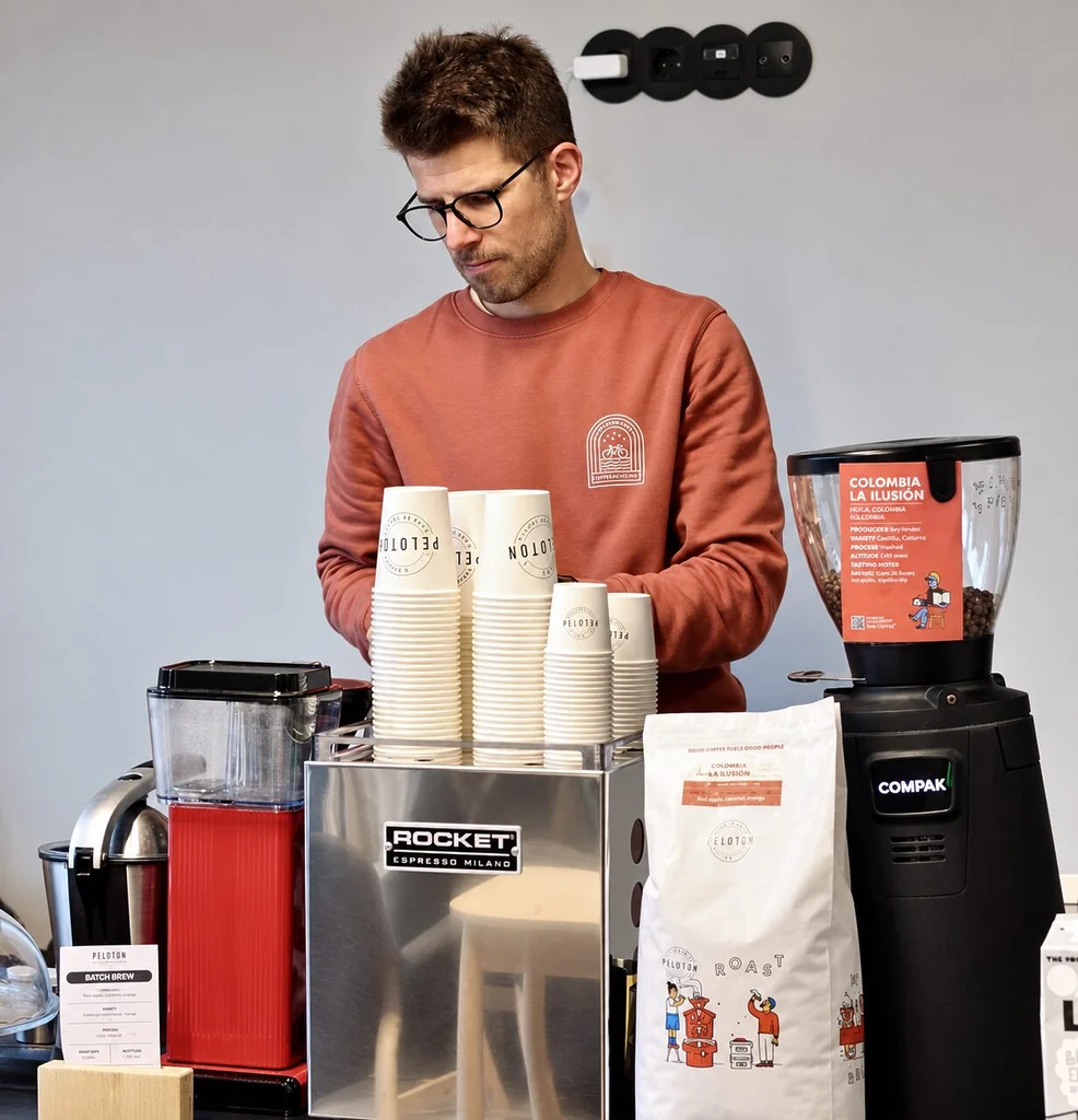 Márcio Borlido prépare le service derrière la machine à espresso et le moulin du Peloton Café.