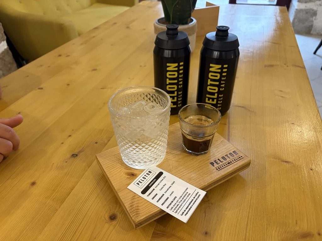 Matcha tonic dégusté par Jeff Tatard au Peloton Café, accompagné d’un verre d’eau et de deux bidons aux couleurs de l’établissement