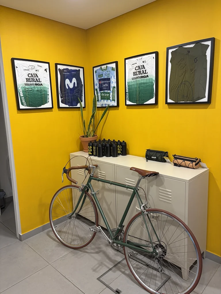 Vélo exposé dans l’espace cycliste du Peloton Café, entouré de maillots, d’affiches et d’accessoires.