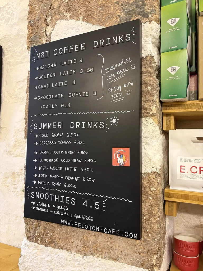 Carte des cafés et boissons proposée au Peloton Café, affichée sur le mur de l’établissement.