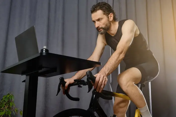 Cycliste qui roule sur home-trainer en regardant un écran