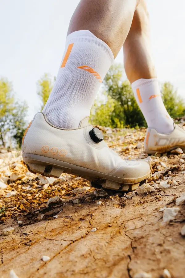 Cycliste qui marche sur la terre avec des chaussures de gravel