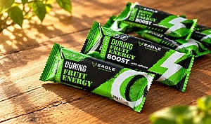 Plusieurs barres énergétiques Eagle Nutrition vertes et noires posées sur une table en bois.