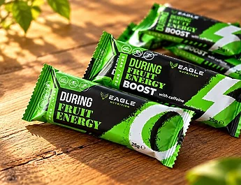 Plusieurs barres énergétiques Eagle Nutrition vertes et noires posées sur une table en bois.
