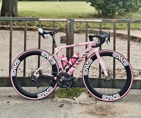 Canyon Ultimate CF SL7 2023 de Timothée avec peinture personnalisée rose, roues DT Swiss ARC 1600 et transmission Shimano 105 mécanique.
