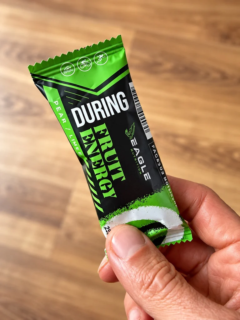 Gros plan sur la barre Eagle Nutrition Fruit Energy classique, saveur poire-citron vert. Une recette fruitée à base de glucides, développée pour accompagner les efforts d'endurance et proposer une alternative aux gels énergétiques traditionnels.