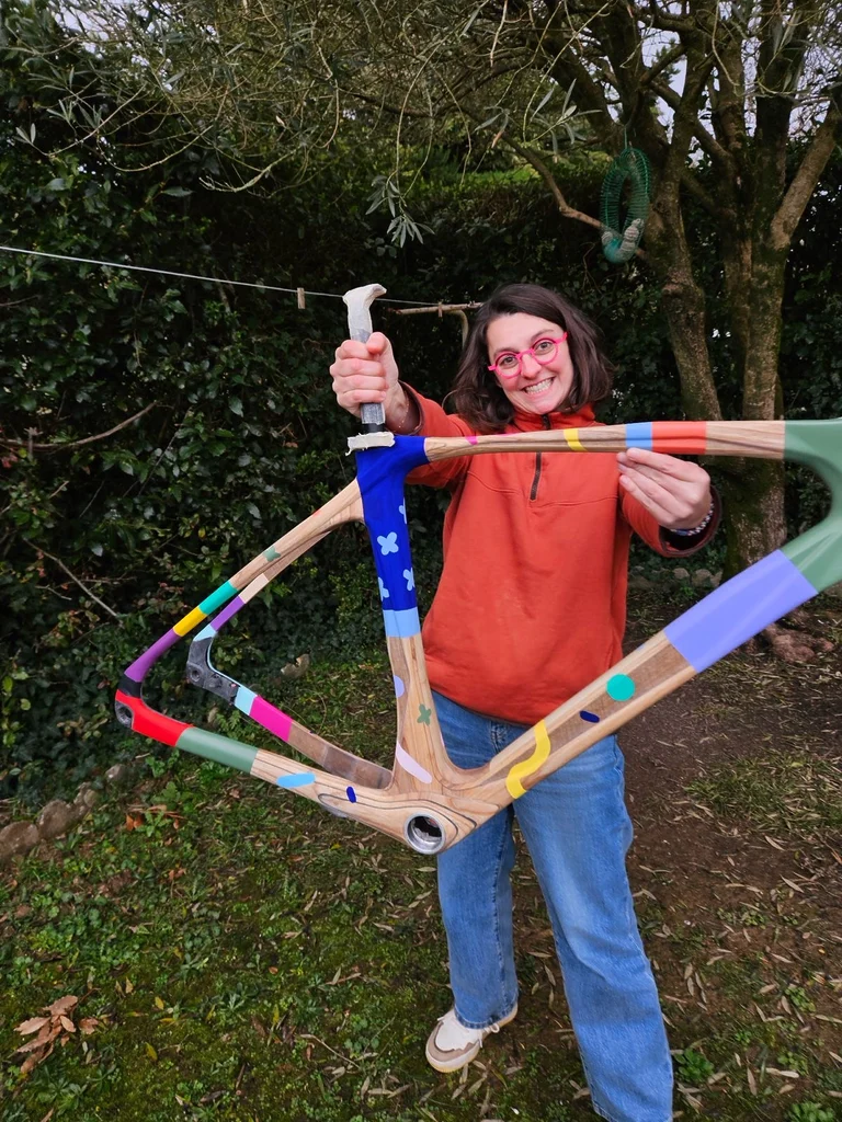 Mathilde AT pose avec le cadre en bois Gonnel Embrun qu’elle a personnalisé avec des formes et motifs colorés. Une création artistique pensée pour être montée, roulée et faire vivre l’art au-delà de l’atelier.