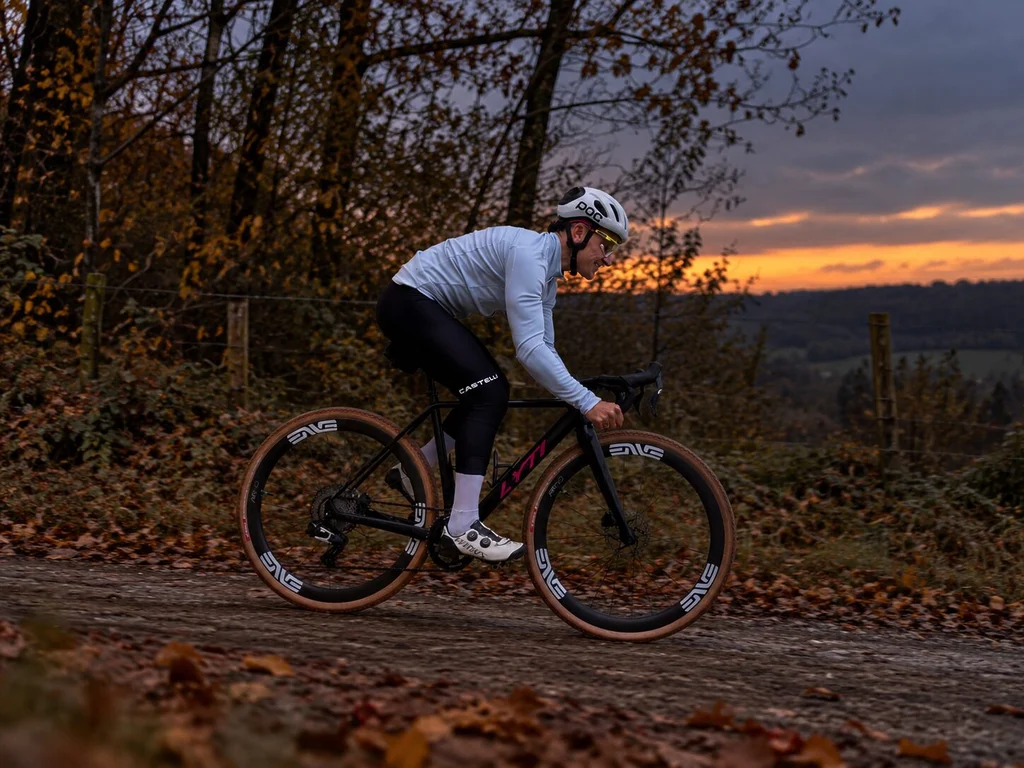 Cycliste en veste Castelli Perfetto 4 Steel Fade sur son gravel LYTI, au crépuscule dans le Vexin, test de la protection thermique Polartec AirCore.