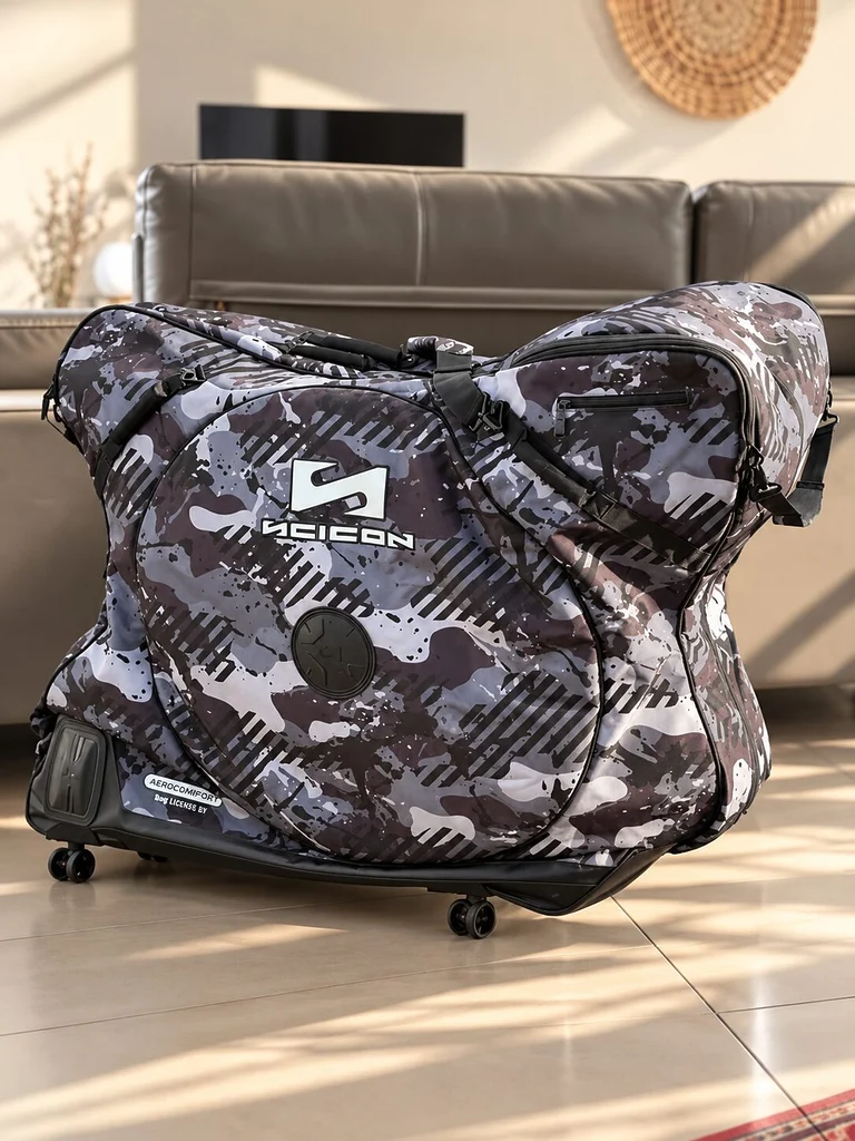 Housse de transport vélo Scicon Aerocomfort 3.1 Gravel en finition Grey Camo, photographiée dans un intérieur lumineux. Vue latérale de la housse avec son logo Scicon, ses sangles de maintien, ses renforts de protection et sa base équipée de roulettes pivotantes.